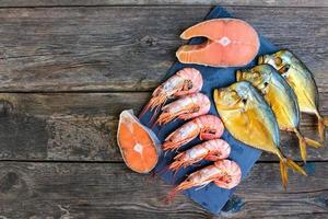 Different seafood fish, shrimp on wooden old background. Top view. Flat lay. photo