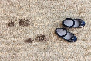 Dirty floor and children's shoes. Concept of child soiled carpet. photo