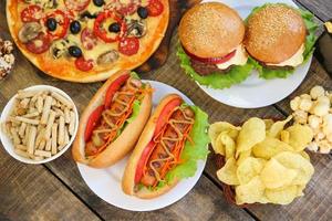 Fast food on old wooden background. Concept of junk eating. Top view. Flat lay. photo