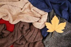 Pile of colorful warm clothes on wooden background. Top view. Flat lay. photo