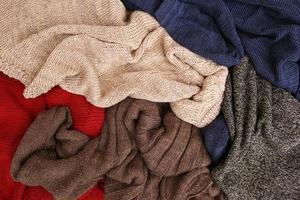 Pile of colorful warm clothes on wooden background. Top view. Flat lay. photo