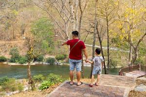 un padre camina participación su hijos mano a explorar el natural aprendizaje recursos en el nacional parque. el concepto de aprendizaje fuera de el aula, hogar escuela, natural aprendizaje recursos. foto