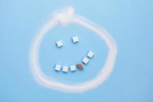 Sugar emoticon, sugar cube teeth with one carious brown sugar cube tooth, junk food photo