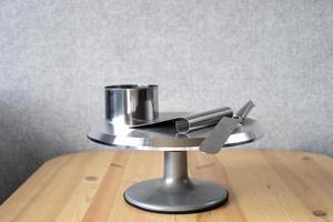 A set of tools for a confectioner lie on a rotating metal table. Spatula, spatula and cake pan photo