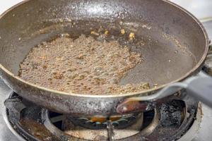 azúcar caramelizar en un fritura pan a gas estufa en cocina foto