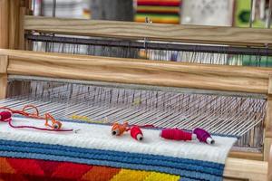 A traditional colorful vintage weaving loom and  thread of yarn. photo