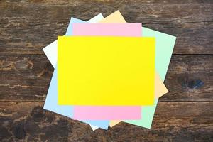 Colored sheets of paper on old wooden background. Top view. Flat lay. photo