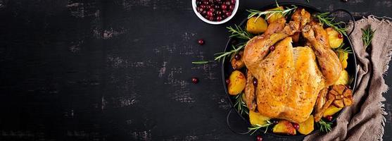 Baked turkey or chicken. The Christmas table is served with a turkey, decorated with bright tinsel. Fried chicken. Table setting. Christmas dinner. Banner. Top view photo