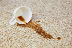 Cup of coffee fell on carpet. Stain is on floor. photo