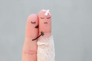 Fingers art of displeased couple. Man is sick, woman feels sorry for him. She kisses and hugs his. photo