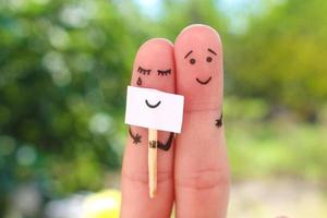 Fingers art of couple. Concept of woman hiding emotions, man is happy. photo