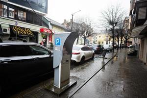 Parking machine in rainy city street. photo