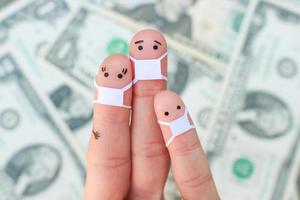 Fingers art of family with face mask on background of money. photo