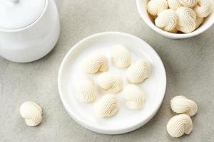Meringue cookies in white bowl, made from whipped flour with sugar and eggs photo