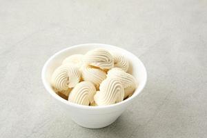 Meringue cookies in white bowl, made from whipped flour with sugar and eggs photo