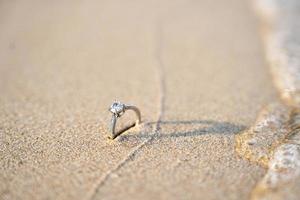 diamante anillos en el arena. y ellos son Boda anillos antecedentes texturas foto