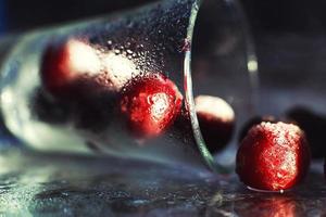 closeup frozen cherry in the glass with reflection . frozen cherry on a dark background macro photo