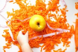 chopped carrots and apple. child takes an apple. fruits and vegetables healthy food for diet photo