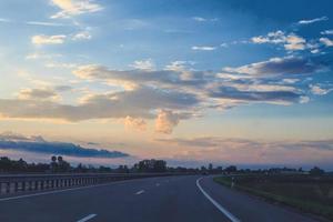 road on a background of clouds in the form of a heart on the sunset sky photo