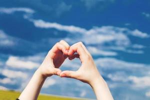 child heart from hands on a background of blue sky photo