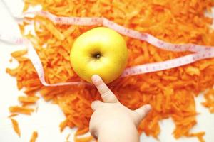 chopped carrots and apple. child takes an apple. fruits and vegetables healthy food for diet photo