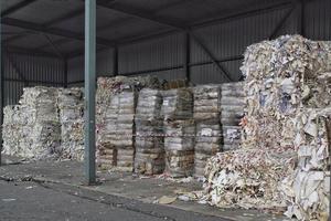 Wastepaper compact texture pile for recycling on sorting plant. Technology of reuse materials. Stack of shredded paper. Save the planet ecology concept. Industry of reduced pollution factory. Close-up photo
