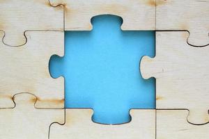 Incomplete and absence wooden puzzle piece with blue backdrop. Missing piece. Mental health concept. Symbol of problem solving. Business creative solution. Communication idea. Hobby, play, fun game photo