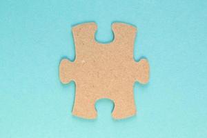 Carton mosaic game detail of jigsaw puzzle element on blue background. Completing task or solving problem concept. World mental health day, autism awareness day. Global communication. Hobby, play photo