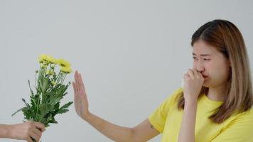 pollen allergiques, asiatique Jeune femme éternuements dans une mouchoir ou soufflant dans une essuyer, allergique à sauvage printemps fleurs ou fleurs pendant printemps. allergique réaction, respiratoire système problèmes video