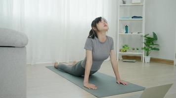 sottile donna praticante yoga su camera di sua condominio. asiatico donna fare esercizi nel mattina. equilibrio, meditazione, rilassamento, calma, bene Salute, felice, relax, salutare stile di vita, dieta, sottile video