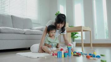 Happy Asia mother play and learn toy blocks with the little girl. Funny family is happy and excited in the house. Mother and daughter having fun spending time together. Holiday, Activity, development video