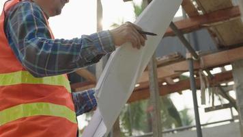 el inspector o ingeniero está inspeccionando la construcción y el aseguramiento de la calidad de la nueva casa usando una lista de verificación. ingenieros o arquitectos o contratistas trabajan para construir la casa antes de entregársela al propietario video