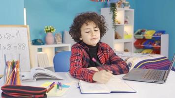 el chico es aburrido y es incómodo con estudiando. el perezoso masculino estudiante quien no querer a estudiar obtiene aburrido y no querer a. video