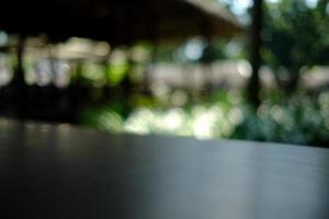 Wooden Table with Nature Bokeh in the Morning, Suitable for Background, Backdrop, and Mock up. photo