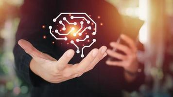 Artificial intelligence or AI Technology concept. Businessman holding hologram of the circuit brain on hand. Smart thinking idea and inspiration innovation. photo