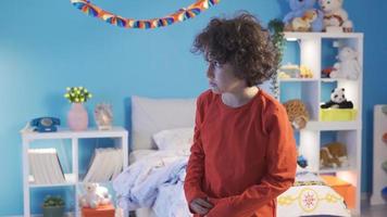 A boy is worried and scared when he sees scary shadows or objects in his bedroom at night. Alone in his room, the boy is worried and afraid of the dark and scary things. video