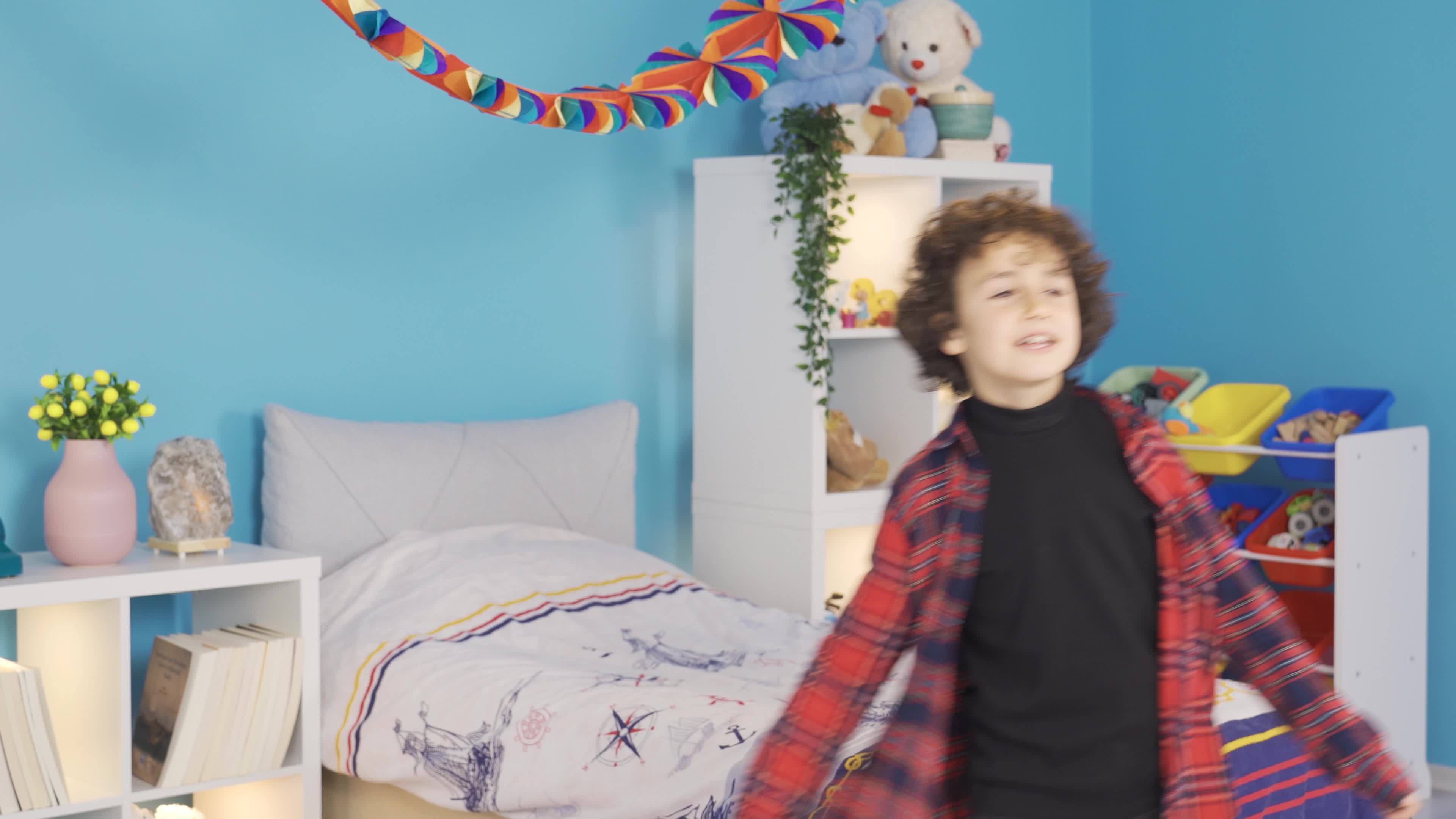 Happy kid dancing in modern kids room. The boy who is happy in his room