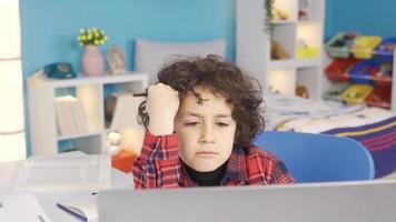 un chico haciendo investigación para su deberes encuentra un nuevo idea o respuesta. primario colegio estudiante haciendo deberes a el escritorio es estudiando con placer. video