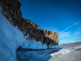 Landscape of Mountain at daytime with natural breaking ice in frozen water on Lake Baikal, Siberia, Russia. photo