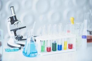 microscopio y vistoso prueba tubos en mesa en laboratorio. Ciencias química concepto. azul tono