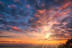 Beautiful cloudscape and dramatic sunset over mountain and sea. photo