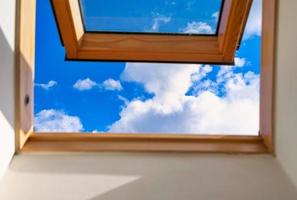 Looking up to the blue cloudy sky through modern square window. Selective blue sky photo