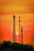 silueta telecomunicaciones antena para móvil teléfono a puesta de sol foto