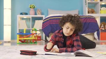 verveeld jongen doet niet willen naar Doen huiswerk. een jongen aan het studeren in zijn kamer is verveeld met aan het doen huiswerk en druppels het. video