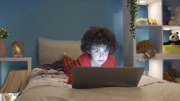 Spiel süchtig Junge spielen Spiele auf Laptop beim Nacht im seine Zimmer. ein Junge spielen ein Video Spiel ist eingetaucht im das Spiel, aufgeregt und glücklich.