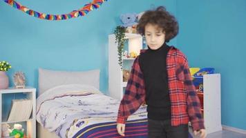 Boy returning home from school sits on the floor tired and thoughtful. The boy who enters his room takes out his bag and sits on the floor and thinks, daydreams, finds ideas, thinks about unhappiness. video