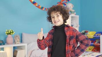 Boy looks at camera, smiles and says ok. The boy in the modern nursery looks at the camera, smiles and says OK with approval. video