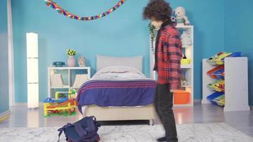 The boy coming home from school sits on the floor thoughtfully. Idea. The boy who comes to his room with his school bag sits on the floor and starts to think. video