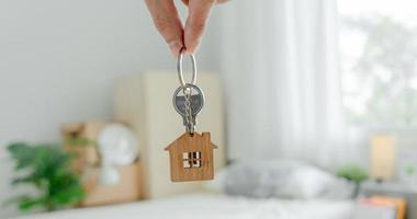 Moving house, relocation. Man hold key house keychain in new apartment. move in new home. Buy or rent real estate. flat tenancy, leasehold property, new landlord, investment, dwelling, loan, mortgage. photo