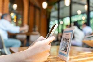 el cliente usa teléfonos inteligentes para escanear códigos qr para pagar en la tienda con pagos digitales sin efectivo. escaneo obtener descuentos. billetera electrónica, tecnología, pago en línea, aplicación bancaria, ciudad inteligente, transferencia de dinero. foto